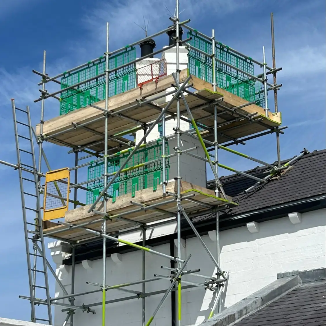Scaffolding platform erected around a chimney for safe roof access