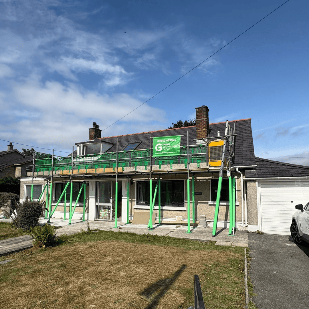 Green Scaffolding Group scaffold along the front roof of a house