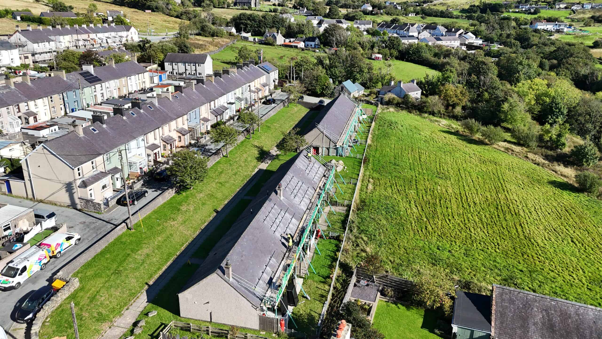 Aerial view of scaffolding along a row of houses beside a grassy field